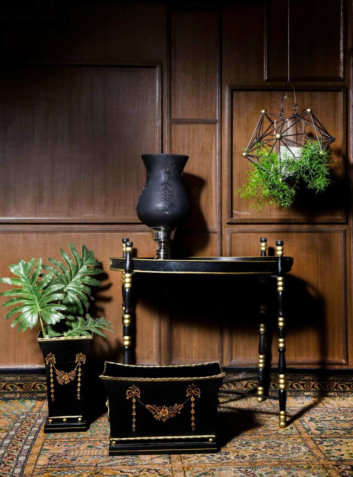 Sophisticated black and gold furniture and decor set against wood paneling in New Delhi